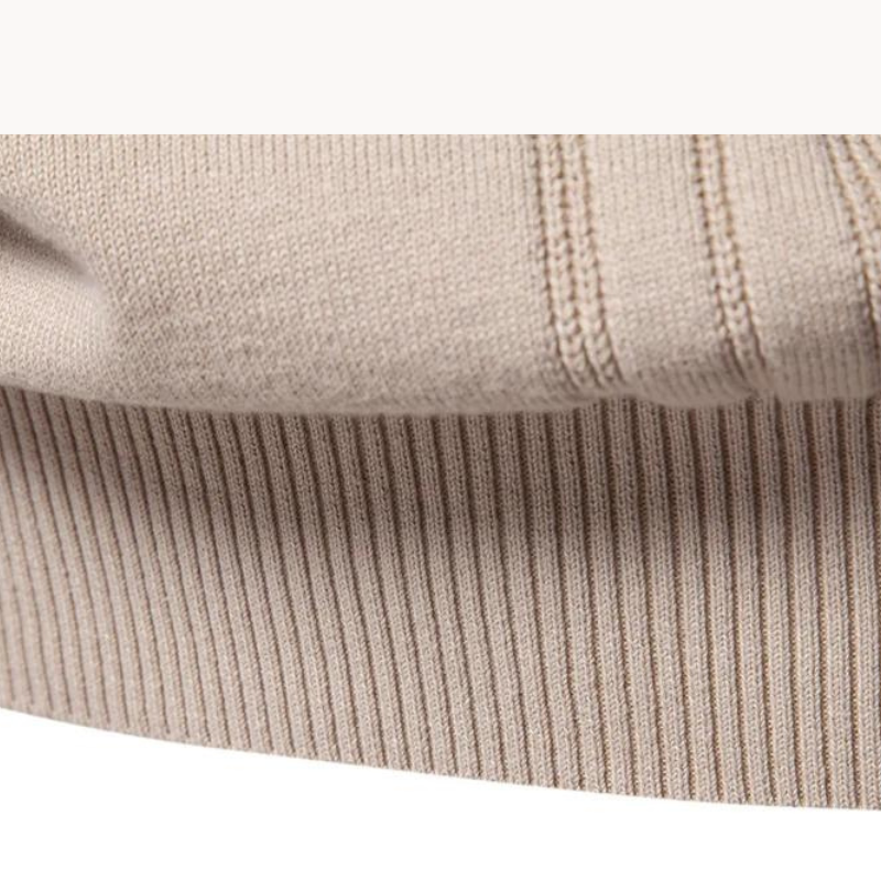Close-up of ribbed hem and stitched stripe detail on beige jumper