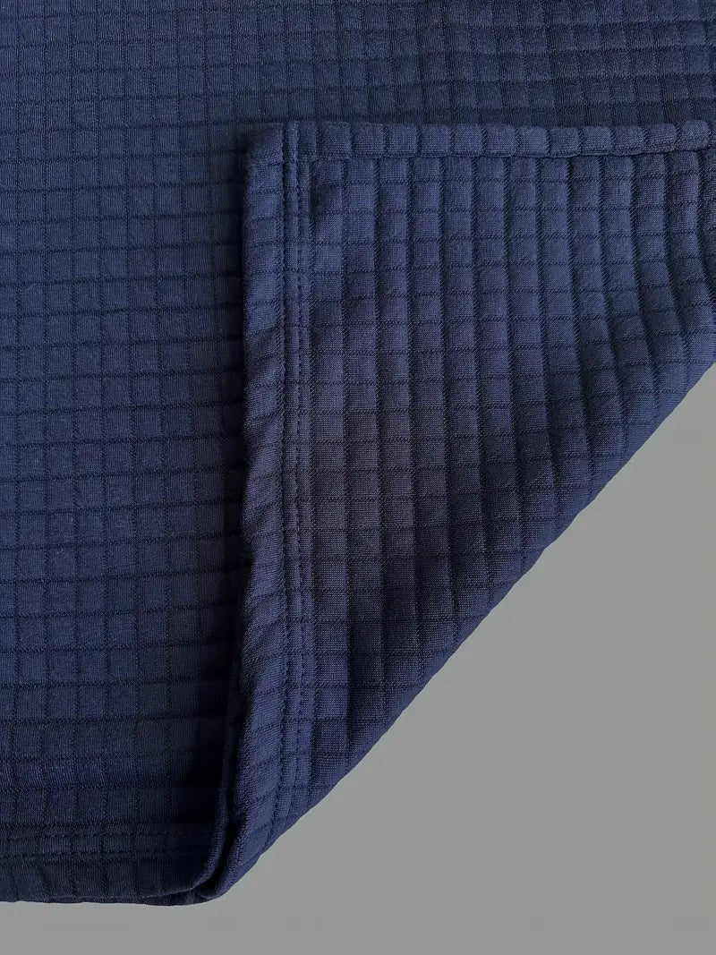 Close-up of hemline and cuff texture on navy waffle-knit polo shirt