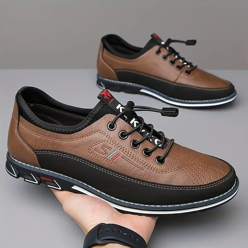 Pair of brown leather lace-up shoes held in hand, showing tread sole
