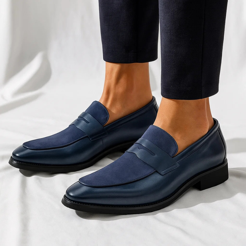 Navy suede penny loafers worn with tailored trousers, showcasing slip-on design