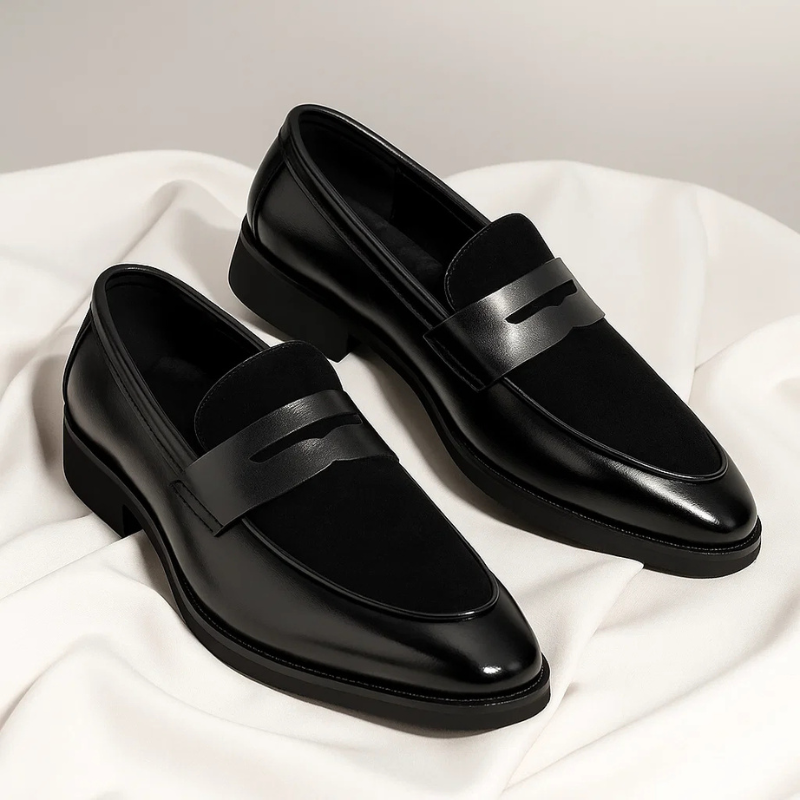 Pair of black leather penny loafers with suede accents and stacked heel