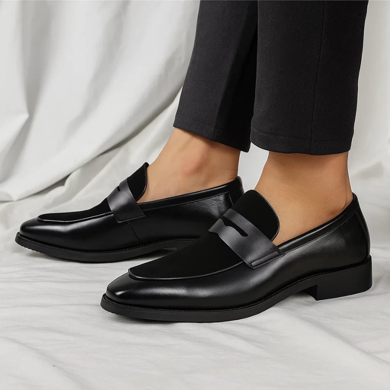 Black suede penny loafers worn with trousers, highlighting smart casual style