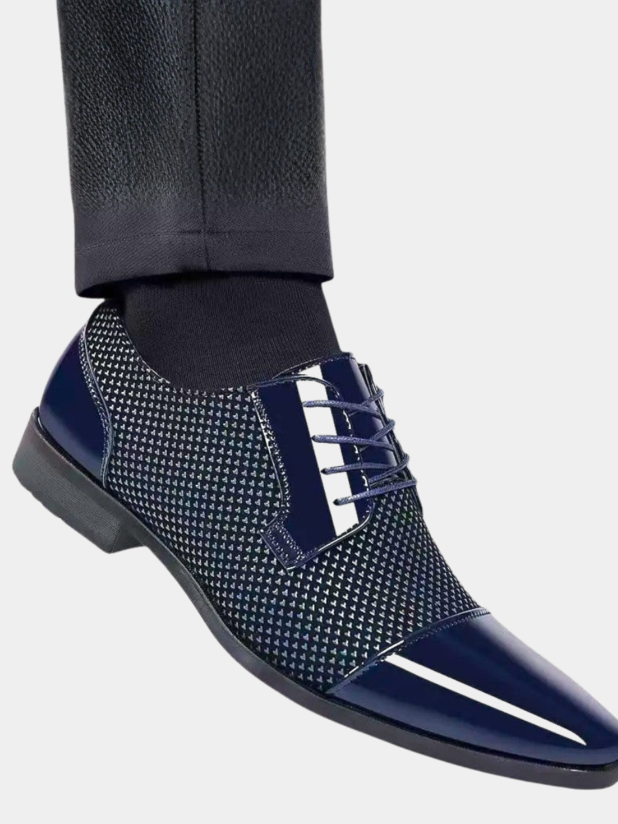 Navy patent cap-toe Oxford shoe worn with tailored trousers and dark socks