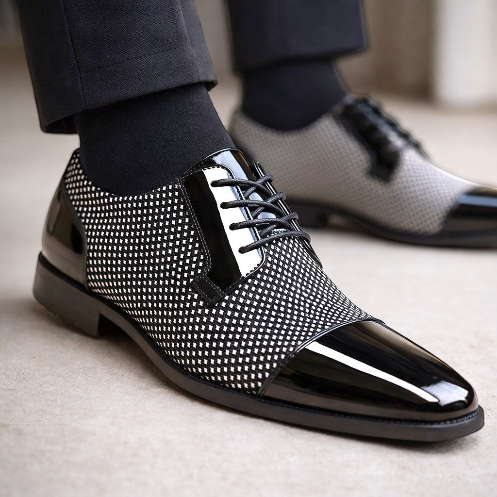 Black and white patterned Oxford shoe with patent toe worn with tailored trousers