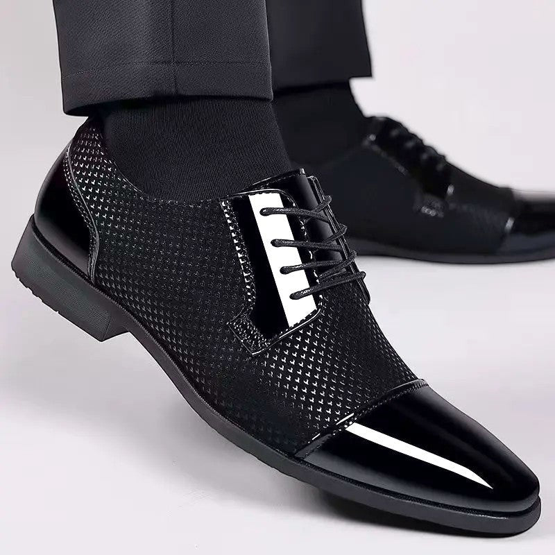 Black patent cap-toe Oxford shoe with textured upper worn with tailored trousers