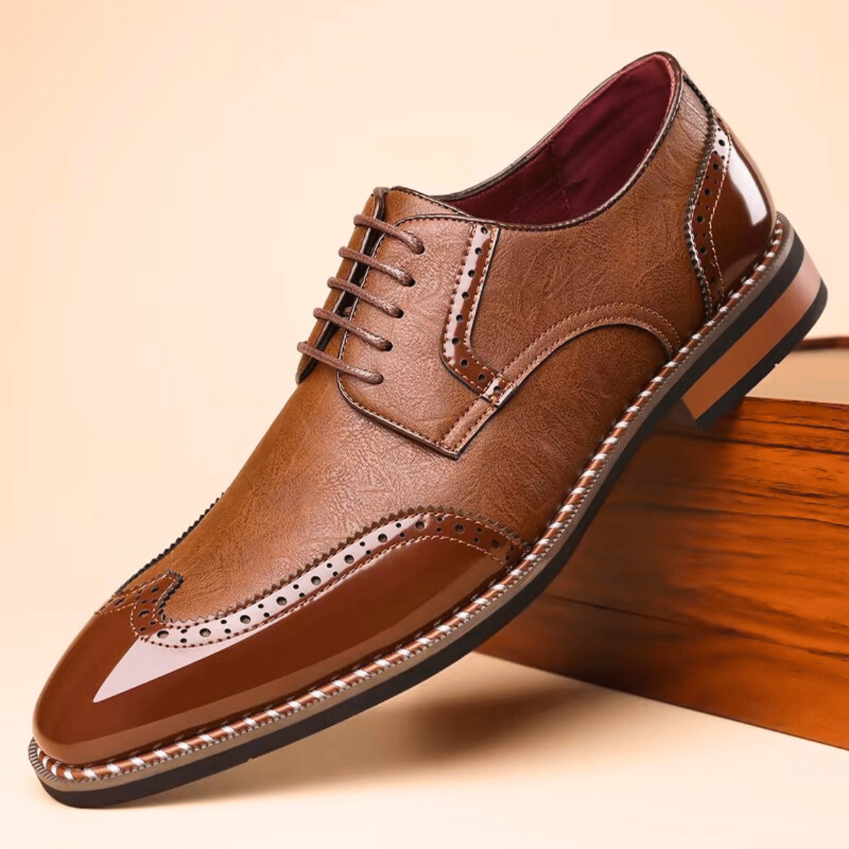 Tan leather brogue shoe with glossy patent wingtip cap and brown laces