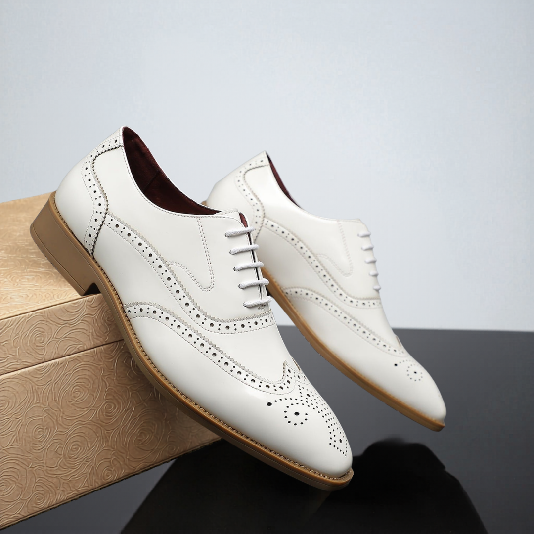 Cream leather wingtip brogues with tonal stitching and tan outsole