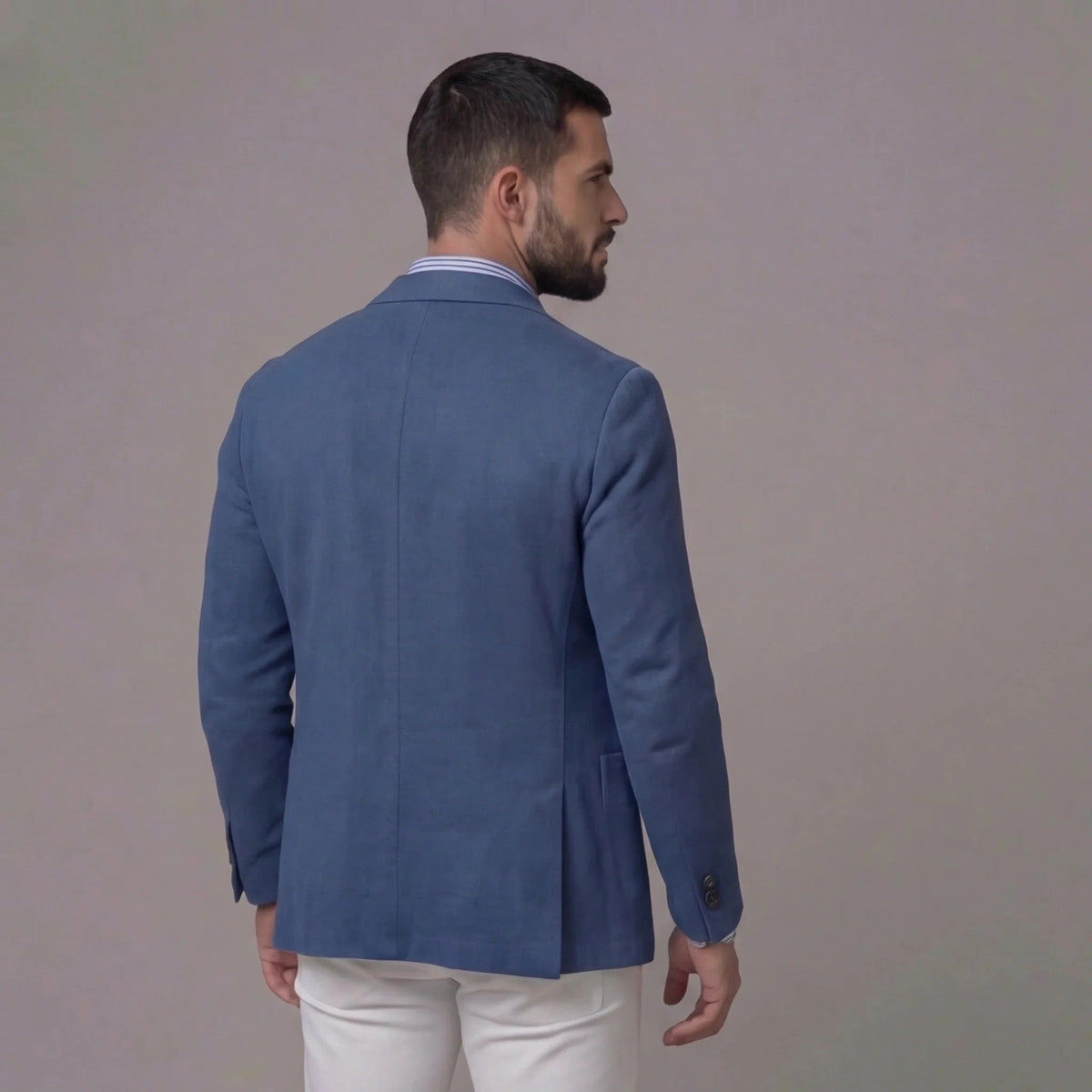 Blue textured blazer worn open over striped shirt, hands on hips