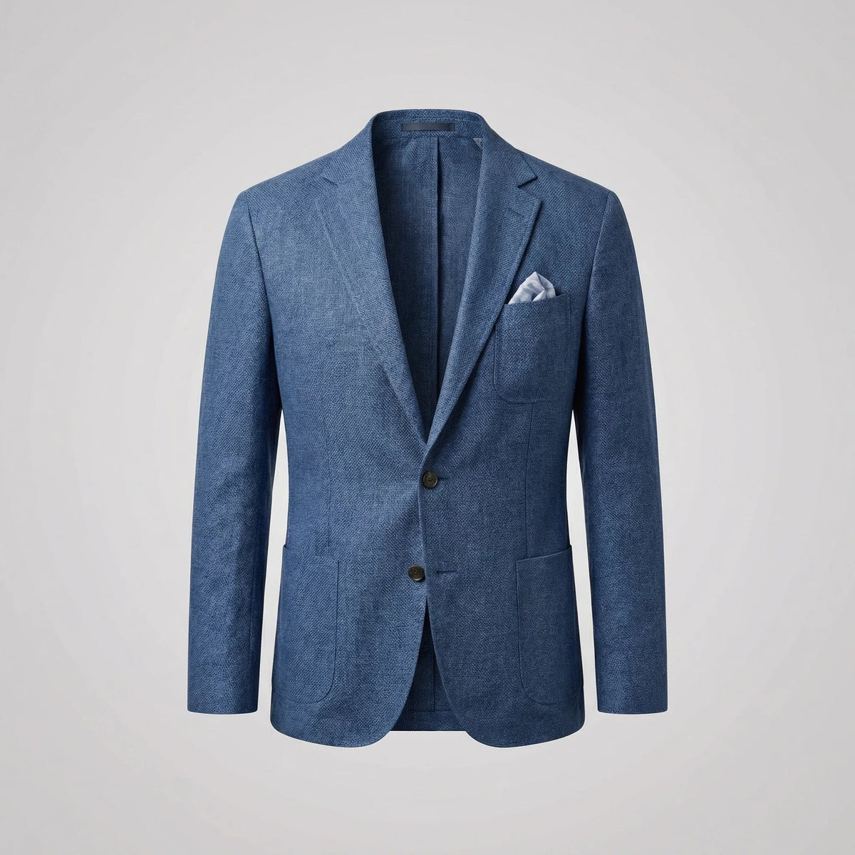 Close-up of textured blue blazer chest pocket with folded glasses