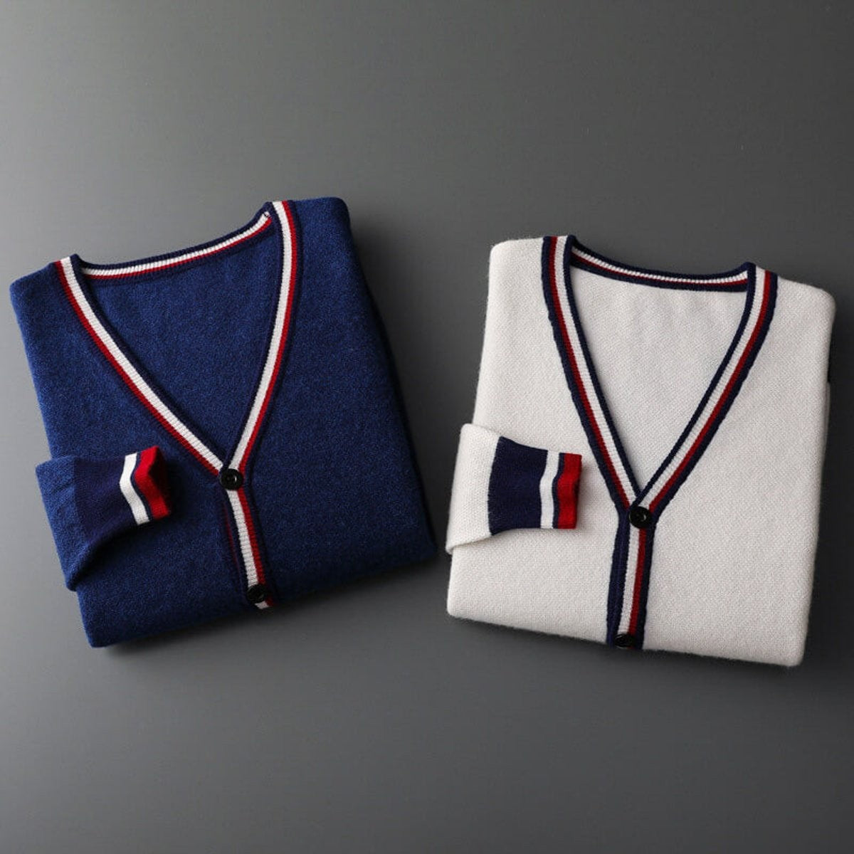 Navy and white V-neck cardigans folded side by side showing striped trim detail