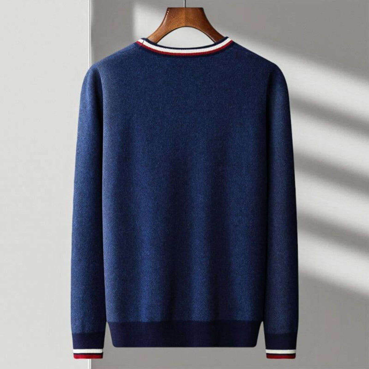 Rear view of navy knitted cardigan showing ribbed cuffs and striped collar