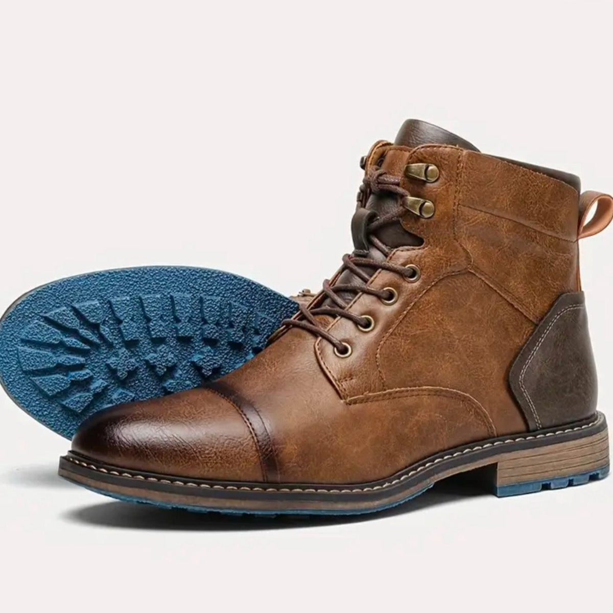 Side view of tan leather cap-toe boot showing textured blue rubber sole