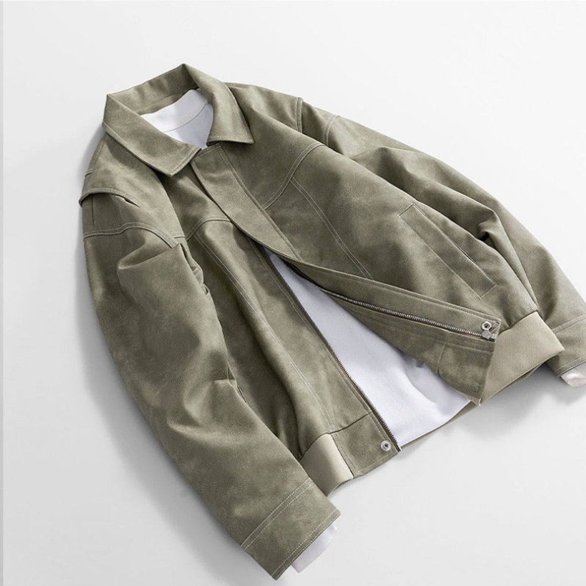 Sage green leather jacket draped showing zip and pocket detail