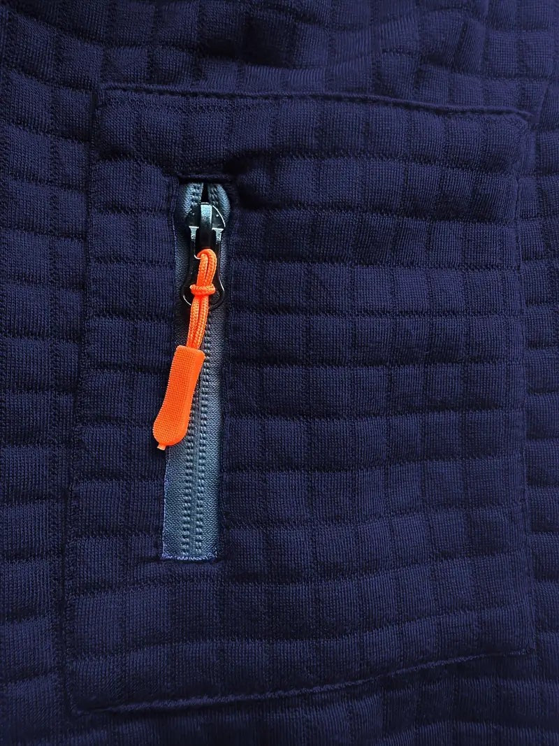 Close-up of navy polo's zip pocket with orange pull tab