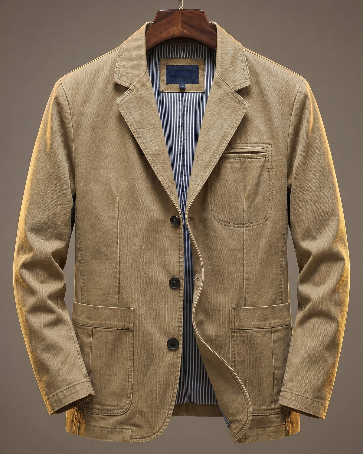 Sandy beige washed denim blazer displayed on wooden hanger, front view