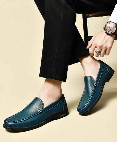 Teal leather loafers worn with tailored black trousers
