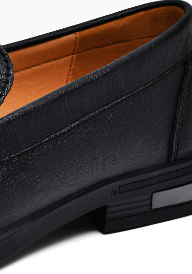 Close-up of black leather loafer showing stacked heel detail