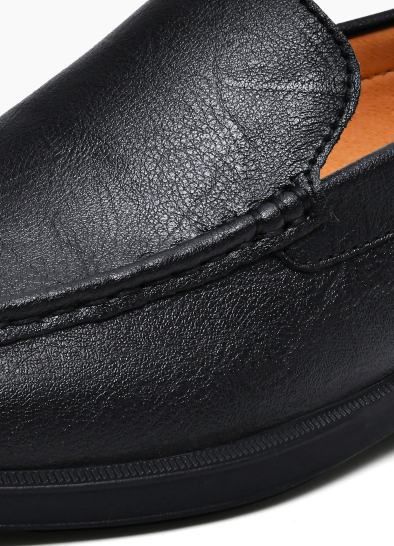 Close-up of black leather loafer highlighting grained texture