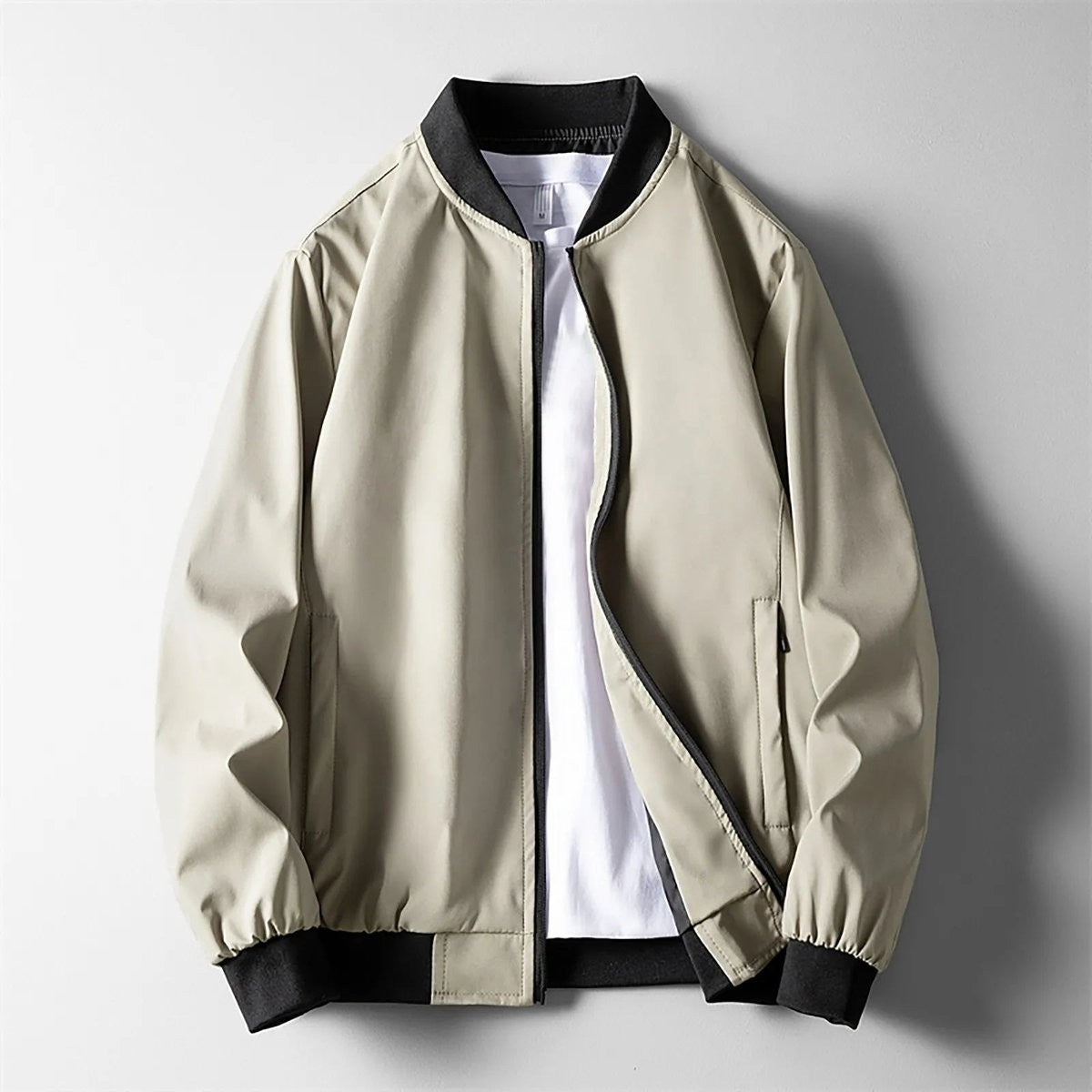 Beige zip-up bomber jacket with black ribbed trim and side pockets