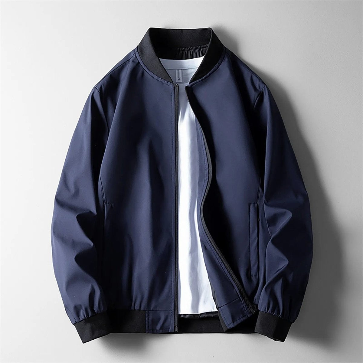 Navy softshell bomber jacket with ribbed collar and elasticated cuffs