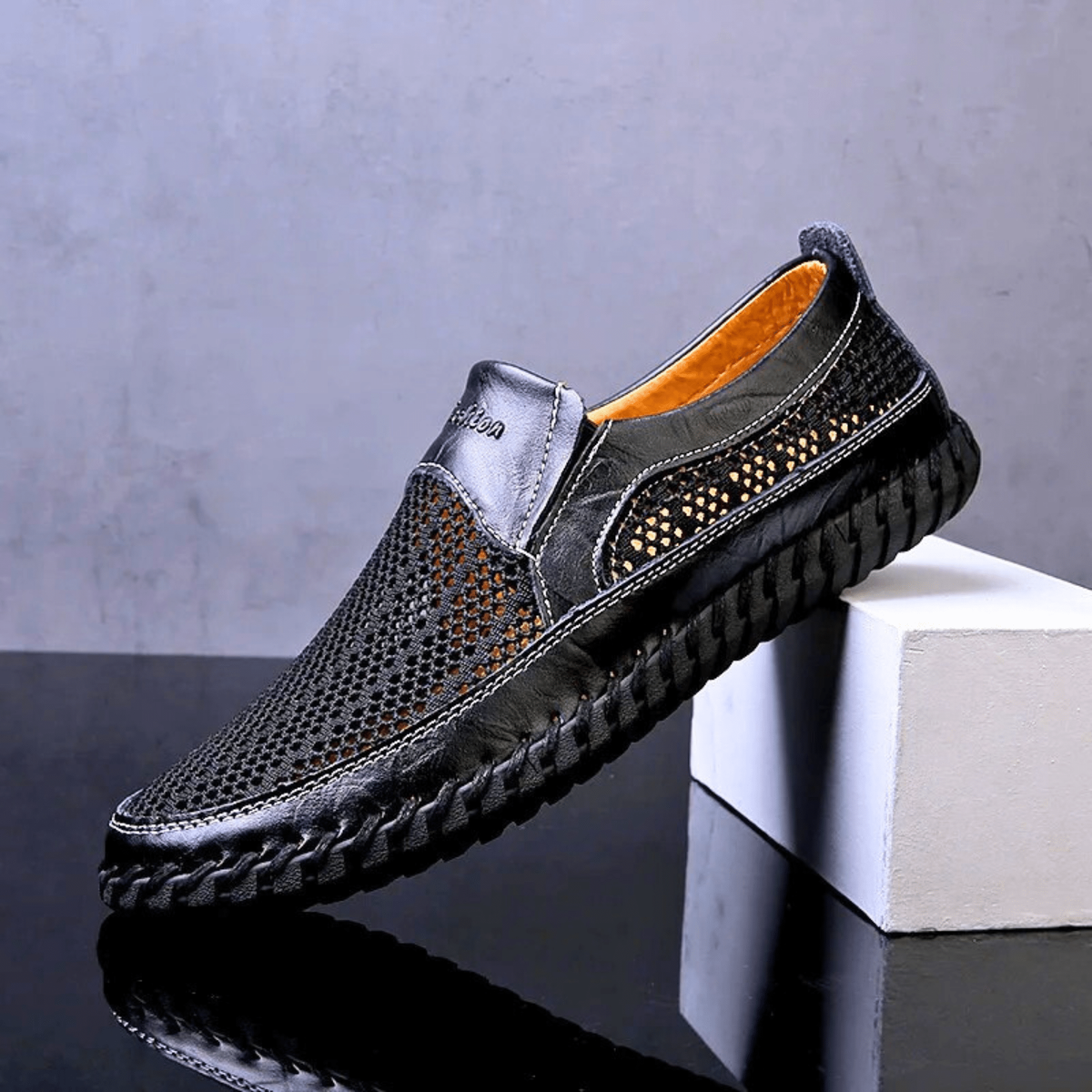 Black leather loafer with tan lining and breathable mesh side panels