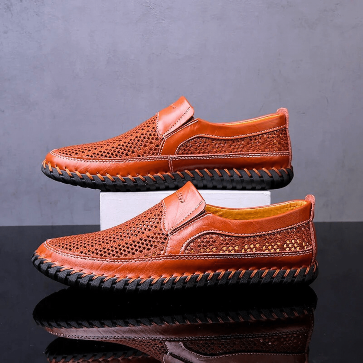 Pair of tan leather loafers with perforated mesh uppers and stitched trim