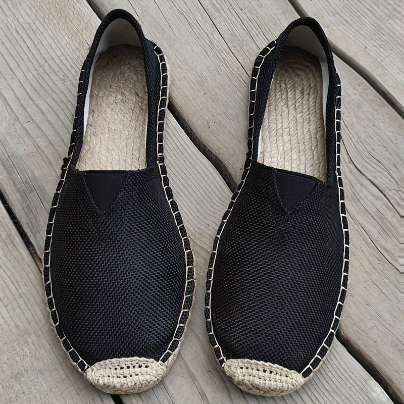 Pair of black woven espadrilles with cream stitched edging, top view